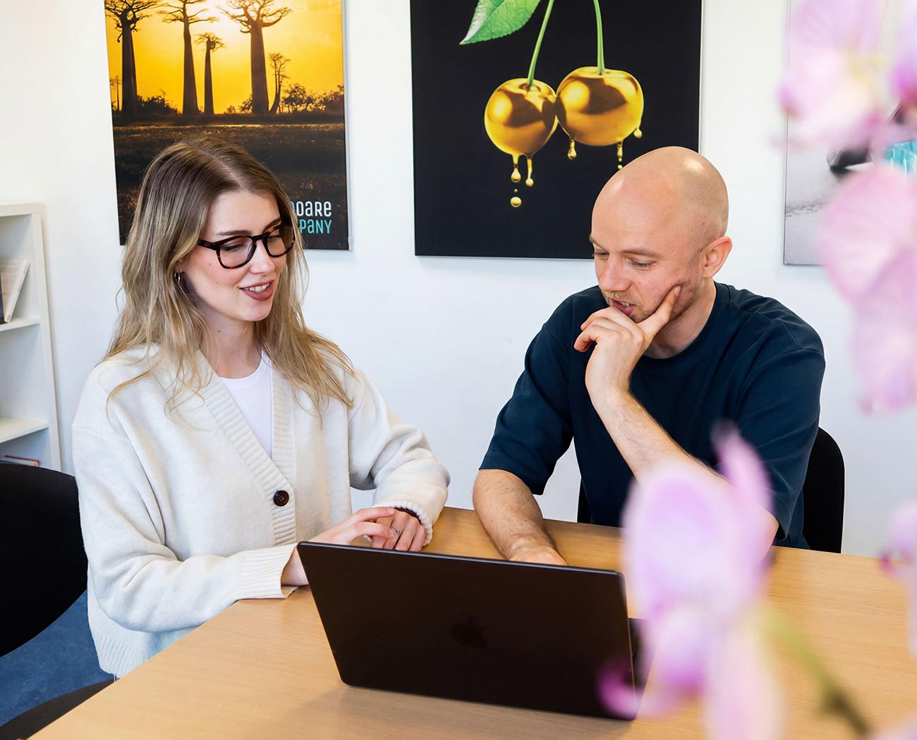 Home | twee mensen houden een bespreking achter een laptop